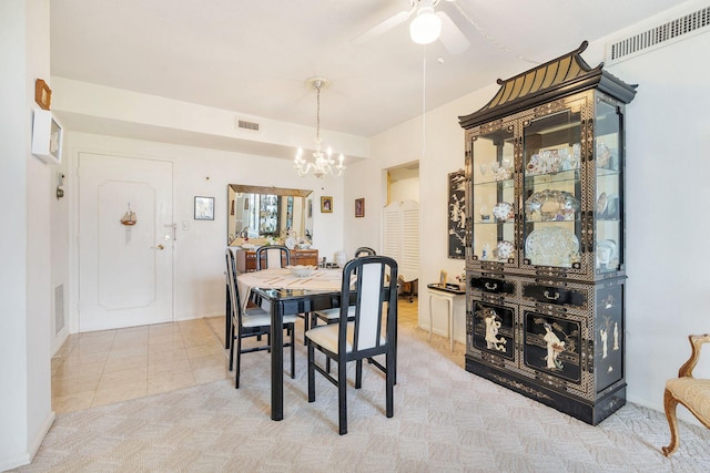 dining area with light carpet, visible vents, and a notable chandelier