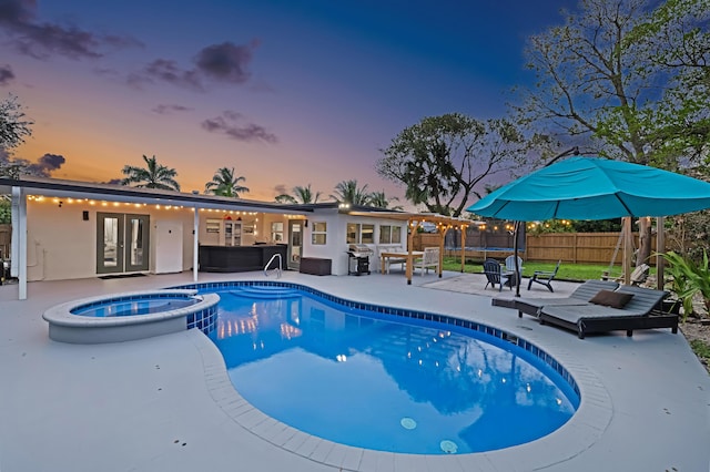 view of pool with a fenced backyard, a grill, a pool with connected hot tub, french doors, and a patio area