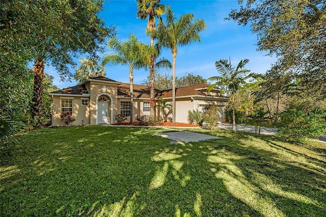 view of front of property featuring an attached garage, a front yard, and stucco siding