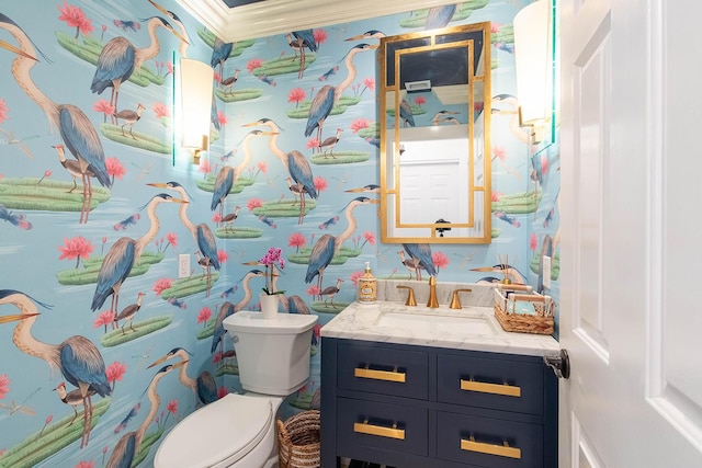 bathroom with vanity, toilet, and wallpapered walls