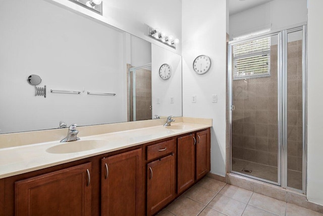 full bath featuring double vanity, a stall shower, a sink, and tile patterned floors