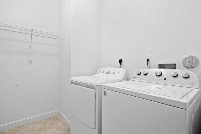 laundry area with washer and dryer, laundry area, baseboards, and light tile patterned floors