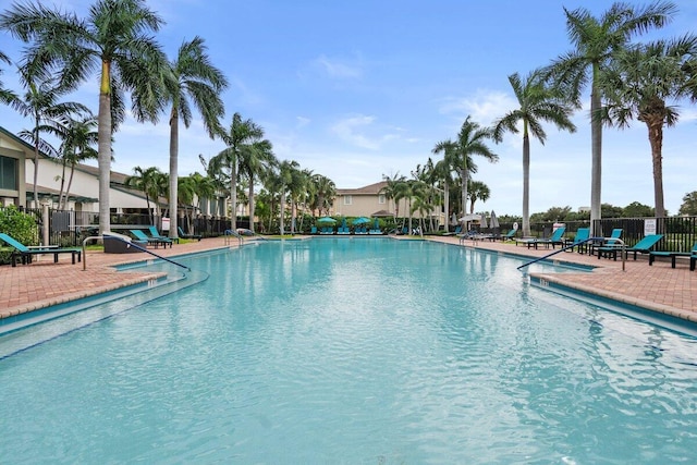 pool with a patio and fence