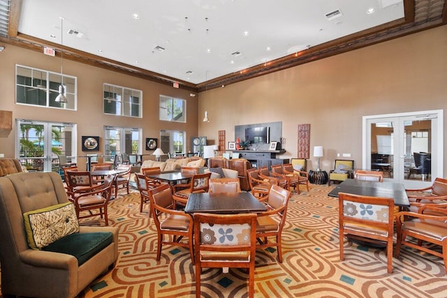 carpeted dining room featuring a towering ceiling, visible vents, ornamental molding, and french doors