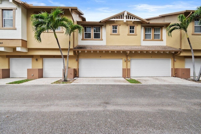 townhome / multi-family property featuring a garage and stucco siding