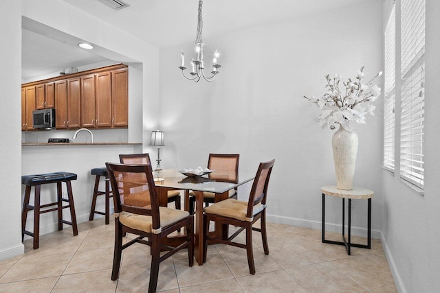 dining space featuring visible vents, baseboards, a chandelier, and light tile patterned flooring