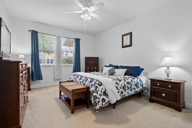 bedroom featuring a ceiling fan, light carpet, and baseboards