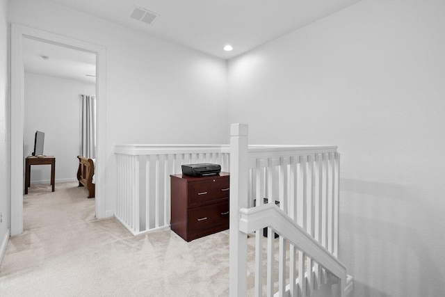 hall with carpet floors, recessed lighting, visible vents, and an upstairs landing