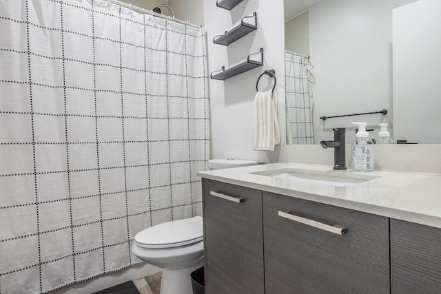 bathroom featuring toilet, vanity, and a shower with curtain