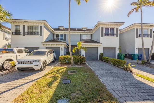 townhome / multi-family property featuring decorative driveway and an attached garage