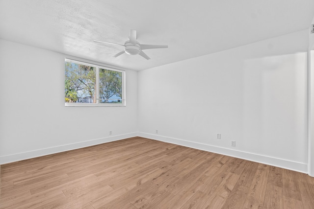 spare room with light wood-style floors, baseboards, and a ceiling fan