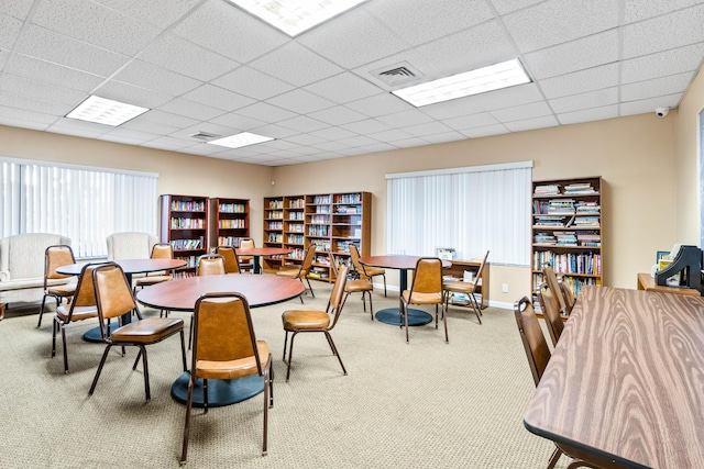 dining area featuring carpet, baseboards, visible vents, and a drop ceiling