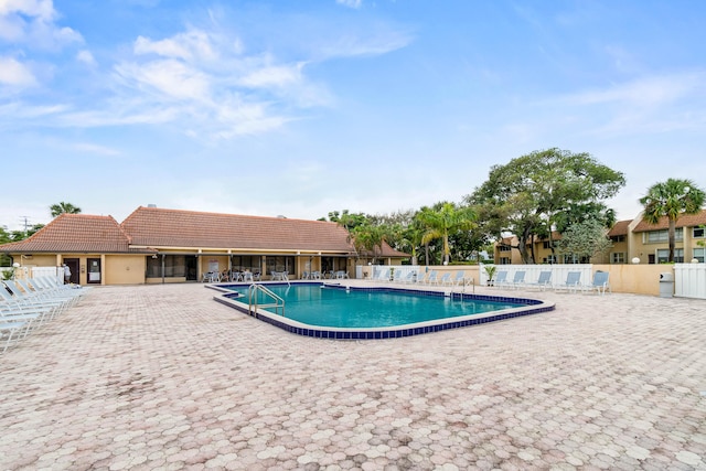 community pool featuring a patio area and fence