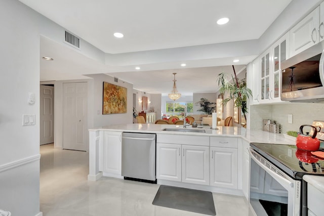 kitchen featuring glass insert cabinets, appliances with stainless steel finishes, white cabinets, and light countertops