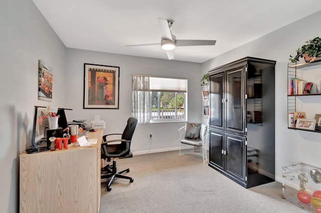 office space with ceiling fan, baseboards, and light colored carpet