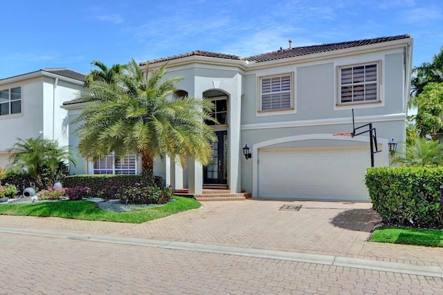 view of front of property featuring a tile roof, decorative driveway, and stucco siding