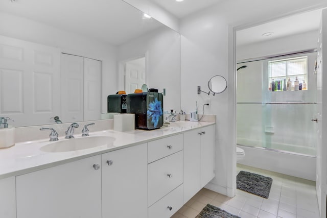 full bathroom with shower / bath combination with glass door, double vanity, toilet, a sink, and tile patterned floors