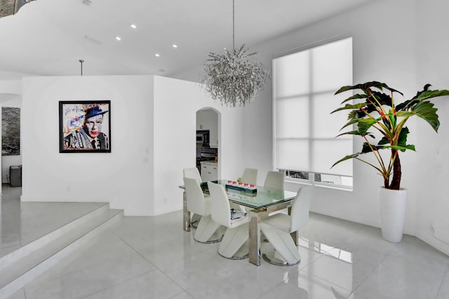 dining area with arched walkways, visible vents, and an inviting chandelier