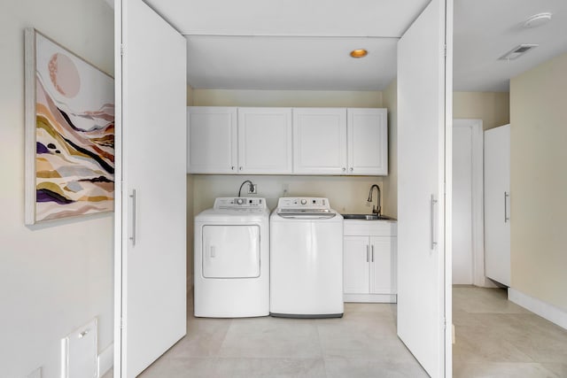 clothes washing area featuring visible vents, a sink, cabinet space, light tile patterned floors, and washing machine and clothes dryer