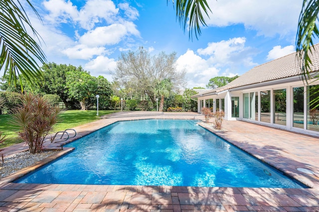 outdoor pool with a patio area and a lawn