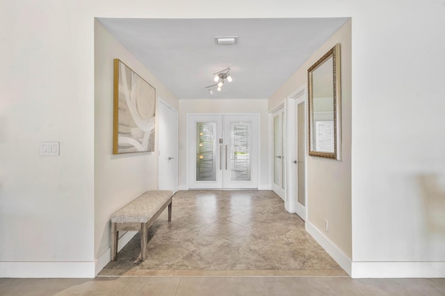 doorway with french doors and baseboards