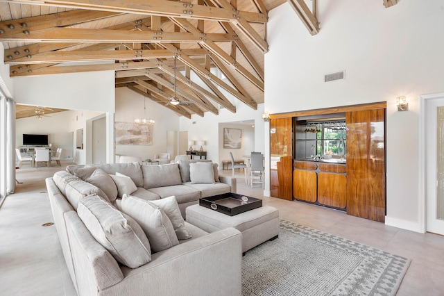 living area with visible vents, high vaulted ceiling, an inviting chandelier, and beamed ceiling