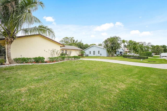 view of front of house featuring a front lawn, concrete driveway, and stucco siding