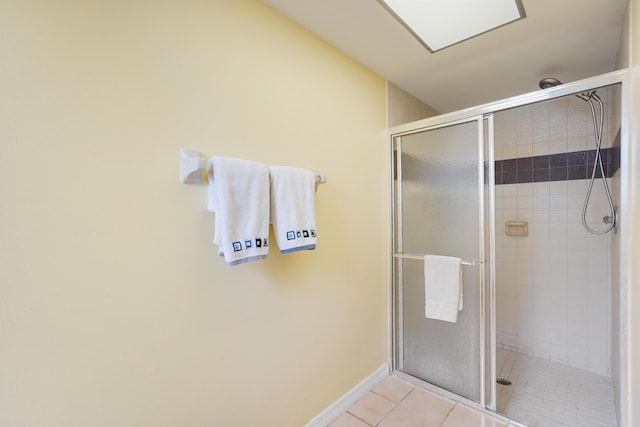 full bath featuring a shower stall, baseboards, and tile patterned floors