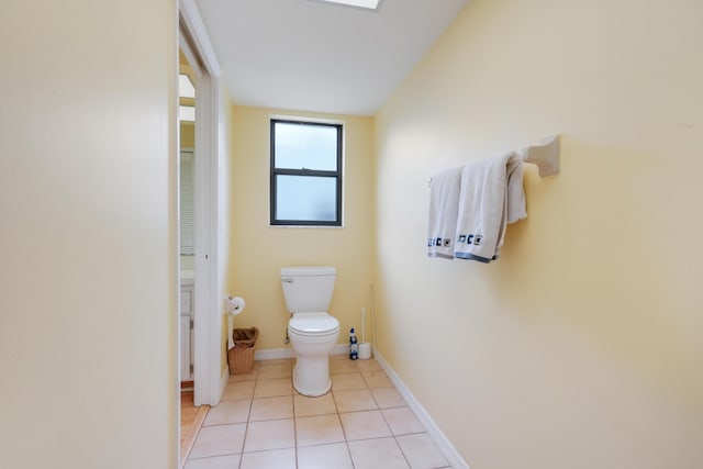 bathroom with toilet, tile patterned flooring, and baseboards