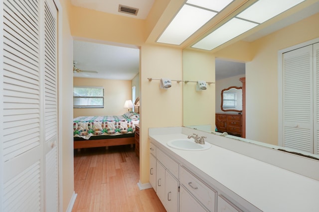 ensuite bathroom with connected bathroom, a skylight, vanity, visible vents, and a closet