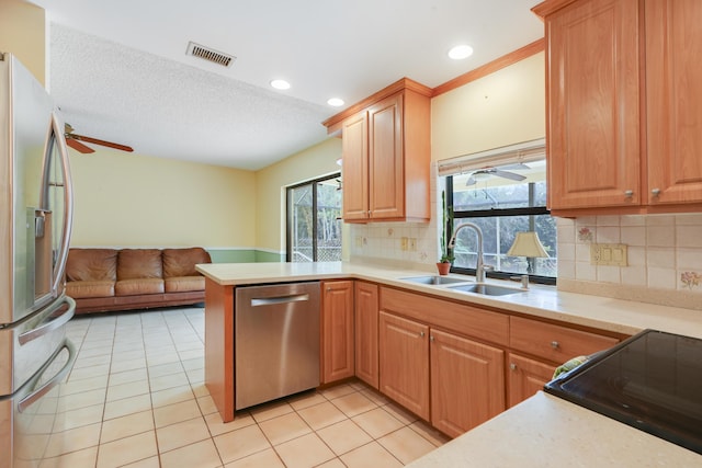 kitchen with visible vents, appliances with stainless steel finishes, a peninsula, light countertops, and a sink