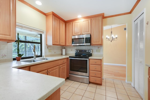 kitchen with light countertops, appliances with stainless steel finishes, hanging light fixtures, and a sink