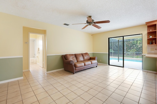 unfurnished living room featuring light tile patterned floors, visible vents, baseboards, ceiling fan, and a textured ceiling