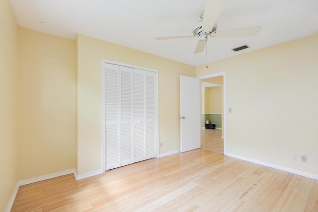 unfurnished bedroom with a closet, visible vents, light wood-style flooring, and baseboards