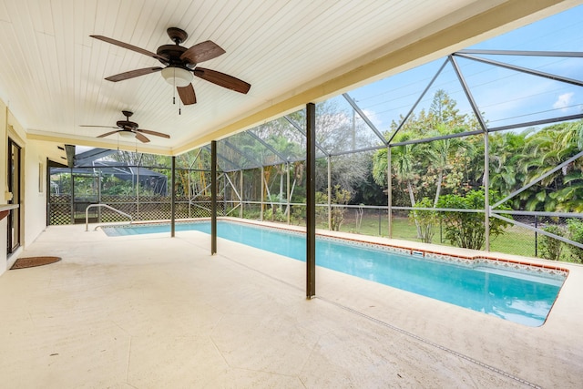 pool with glass enclosure, a patio, and ceiling fan