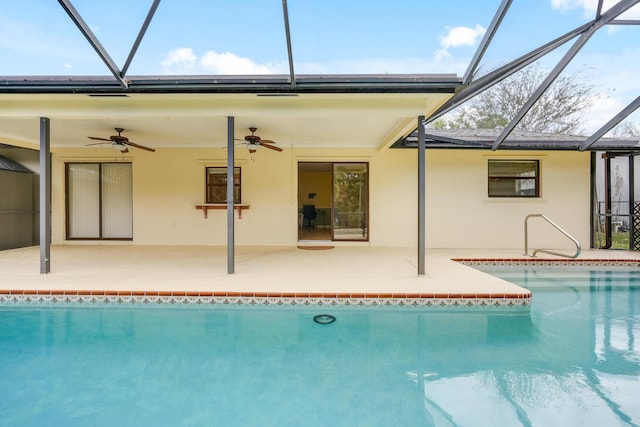 pool featuring ceiling fan, glass enclosure, and a patio area