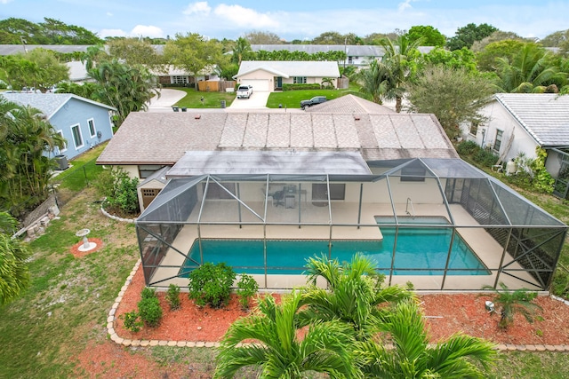 pool with glass enclosure, a patio area, and a residential view