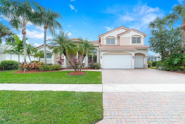 view of front of property with a tile roof, an attached garage, decorative driveway, a front yard, and stucco siding