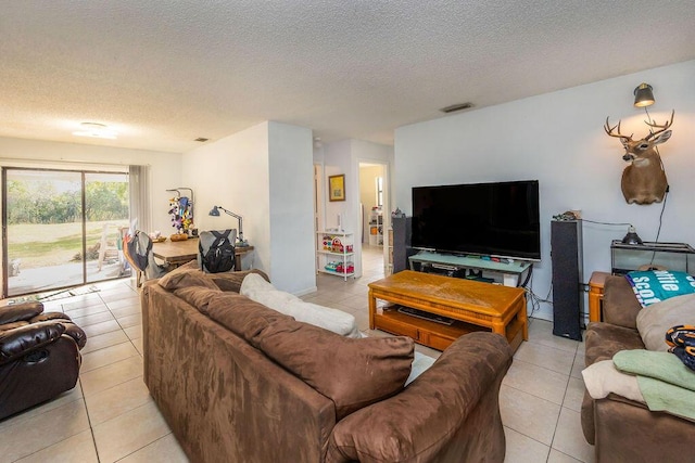 living area with visible vents, a textured ceiling, and light tile patterned flooring