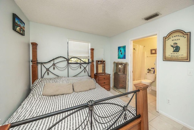 bedroom featuring light tile patterned floors, a textured ceiling, visible vents, baseboards, and ensuite bath