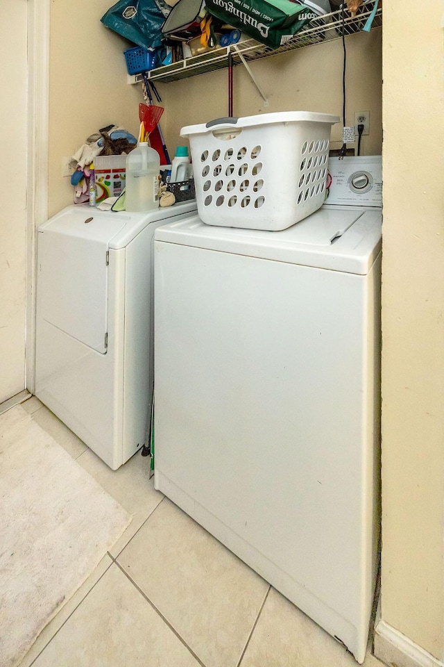 laundry room featuring laundry area, washer and dryer, and light tile patterned flooring