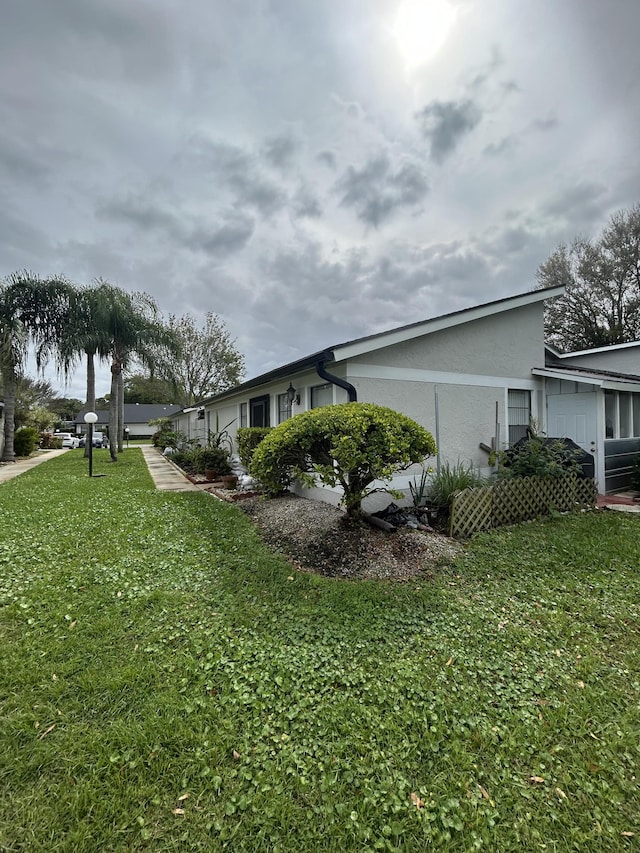 view of side of property with a yard and stucco siding