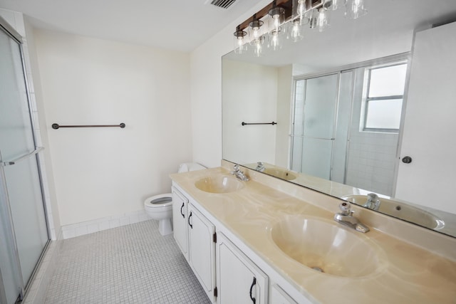 bathroom featuring a shower with shower door, tile patterned flooring, a sink, and toilet