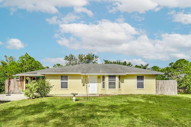 view of front of property featuring fence, a front lawn, and stucco siding