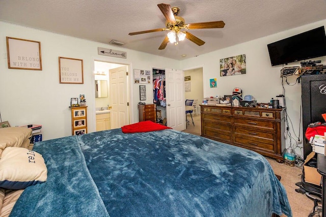 bedroom featuring carpet, visible vents, ceiling fan, and a textured ceiling