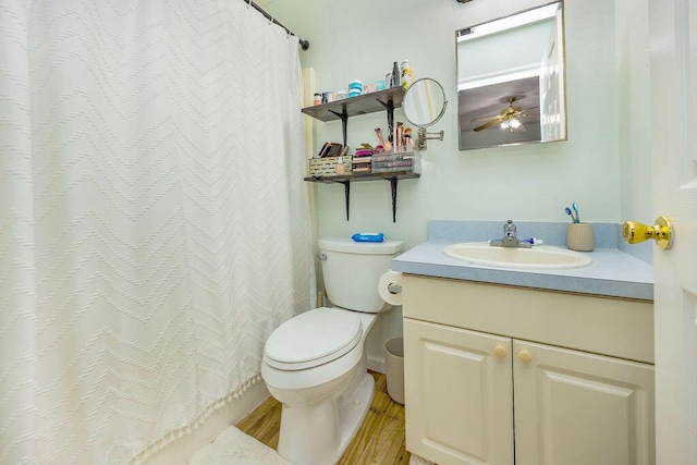 bathroom featuring toilet, wood finished floors, and vanity