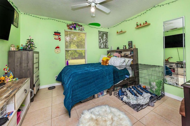 bedroom featuring a textured ceiling, tile patterned flooring, a ceiling fan, and baseboards