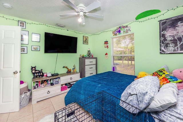 tiled bedroom featuring ceiling fan and a textured ceiling