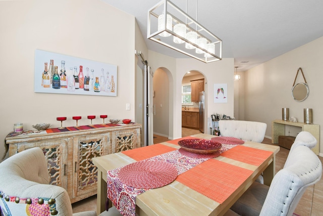 dining room with arched walkways and a dry bar