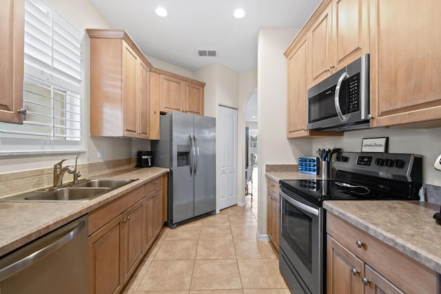 kitchen featuring arched walkways, visible vents, stainless steel appliances, light countertops, and a sink